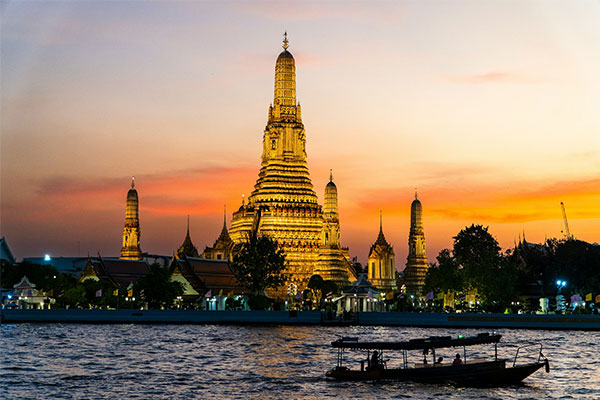 Wat Arun Kuil Fajar Bangkok saat matahari terbenam di tepi Sungai Chao Phraya
